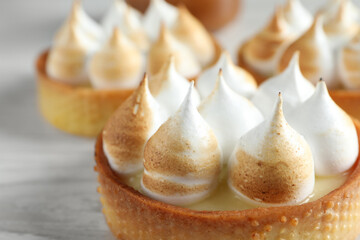 Tartlets with meringue on table, closeup. Tasty dessert