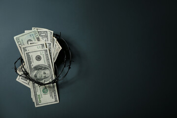 Dollar banknotes with barbed wire on dark background. Sanctions concept