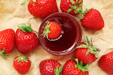 Bowl of sweet strawberry jam and fresh berries on table