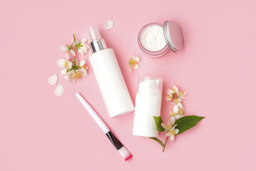 Composition with cosmetic products and beautiful jasmine flowers on pink background
