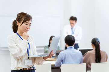 Fototapeta premium オフィス・会議室にいるパソコンを持ったビジネスウーマン・女性（困る・悩む） 