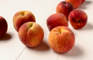 Many sweet peaches on white wooden background