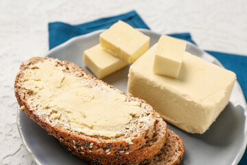 Plate with fresh butter and tasty toast on white background