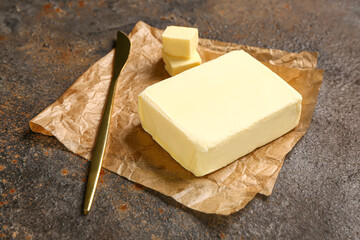 Baking paper with fresh butter on dark background