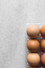 Top view of a crate of eggs on a marble surface, Eggs in a transparent plastic crate, organic eggs on a table