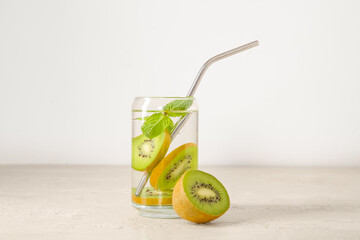 Glass of infused water with kiwi and mint on white background