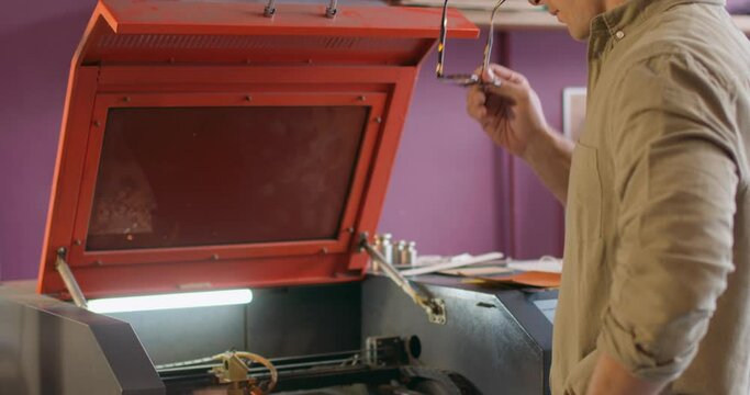 professional craftsman make high-quality patterns on laser engraving equipment, tool, Slow motion hobby, decoration, art. creativity. guy makes embossed pattern on leather surface on belt, wallet, bag