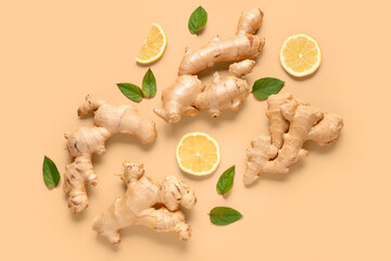 Fresh ginger roots with slices of lemon and leaves on orange background