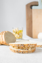 Feta cheese sandwich on a table, marinated feta cheese cubes in a toasted bread. Cheese cubes with tomato and herbs on bread