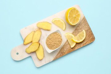 Slices of fresh ginger root, lemon and bowl with dried powder on blue background