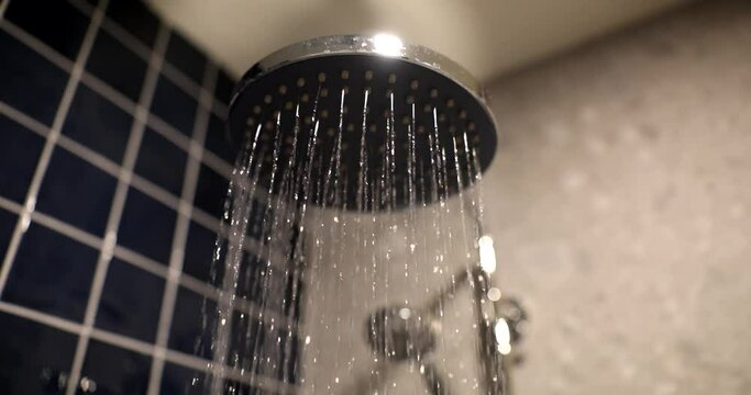 The flow of water from the shower crane in the bathroom, close-up. Modern plumbing, hygienic procedures