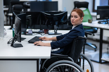 Fototapeta na wymiar Caucasian woman in wheelchair at work desk.