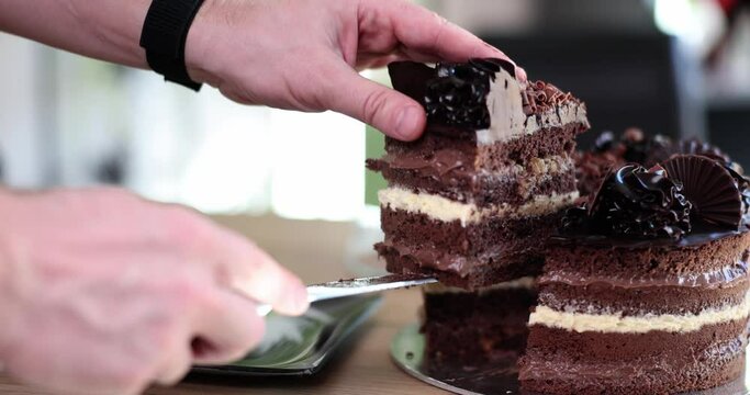 A man cuts a round chocolate cake, hands close-up. Healthy keto dessert, tea party, delicious pastries