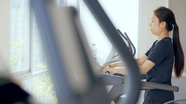 Fitness female walking on treadmill. Asian woman workout cardio and training at gym