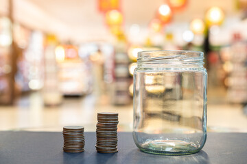 Coins in glass jars on table against blurred background concept of savings