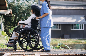 young asian physical therapist working with senior woman on walking with a walker