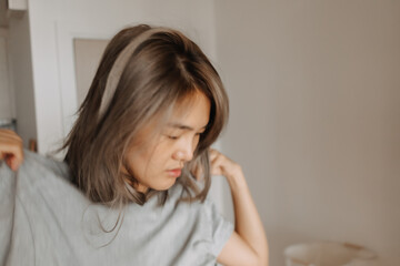 Fototapeta premium Daily lifestyle portrait of sleepy face asian woman wearing t-shirt in the house