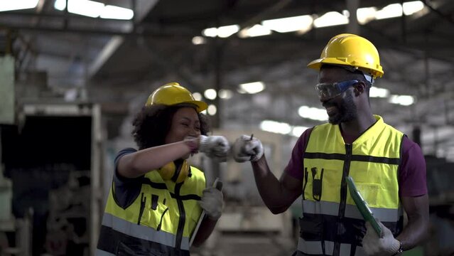 group of African American worker engineers man and woman excited and celebration to work done success together raised hand up to yes in Manufacturing Factory.happy jump to dancing after work finish
