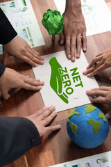Cohesive group of business people forming jigsaw puzzle pieces in net zero icon symbol as eco...