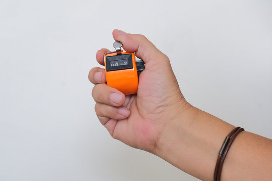 Close-up shot of a hand holding an orange mechanical counter