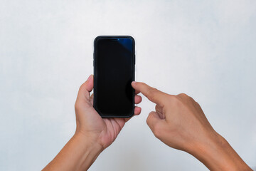Isolated close-up shot of hands dialing smartphone over white background