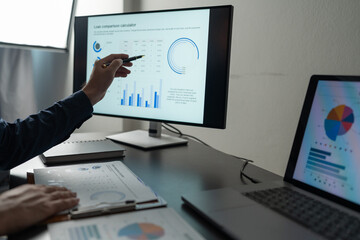 Businessman analyzing financial data statistics on pc computer pointing at screen with graph Chart showing company growth using easy accounting software to plan. Management for start-up business.