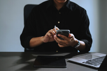Businessman using mobile phone, tablet. and laptop Closeup on blurred background.