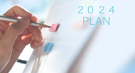 2024 event planning, Business plan and to do list concept. Woman hand with a pencil writing on...