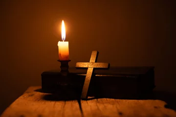 Foto op Plexiglas Light candle with holy bible and cross or crucifix on old wooden background in church.Candlelight and open book on vintage wood table christianity study and reading in home.Concept of christ religion © doidam10