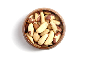 Brazil nuts in wooden bowl isolated on white. Peeled brazil nuts, top view