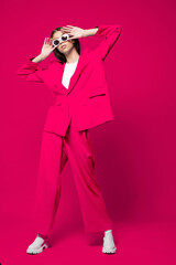 Fashion asian female model in pink suit, white boots and sunglasses.