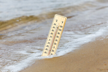 Thermometer on the sandy beach
