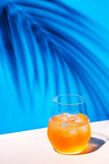 Bee's Knees alcoholic cocktail drink with dry gin, lemon juice and honey syrup, summer blue bright background, hard light and shadows