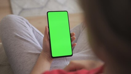 Point of View of Child at Living Room Using Phone With Green Mock-up. Phone With Green Mock-up Screen Chroma Key Surfing Internet Watching Content Videos Blogs Learning. Girl Playing Video Games. - Powered by Adobe
