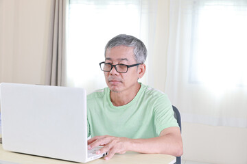 seniors man working at home on laptop computer - Lifestyle senior concept. Ages in tech