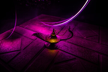 Antique Aladdin arabian nights genie style oil lamp with soft light white smoke, Dark background.