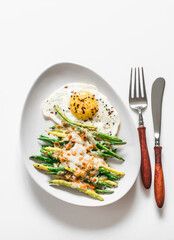 Mozzarella, lemon bread crumbs baked green string beans and fried egg on a light background, top view