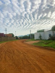 dirt road at a compound in South Sudan witch cloud sky