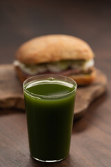 Green matcha drink in tumbler glass with sandwich on background