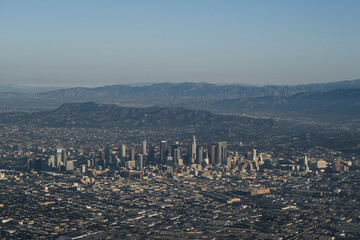 Obraz na płótnie Canvas An aerial view of Downtown Los Angeles, showing the LA skyline and the mountains and valleys in the distance.