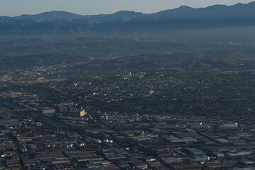 A freeway cuts through a cityscape of Los Angeles,' urban sprawl, with a seemingly endless expanse of mostly low-rise, single-story buildings.