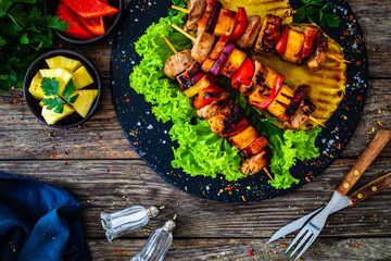 Meat skewers - grilled pork loin, bell pepper and pineapple in teriyaki sauce  on wooden background