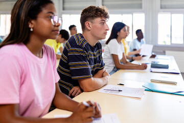Group of high school students listening teacher during lecture in classroom. Education concept.