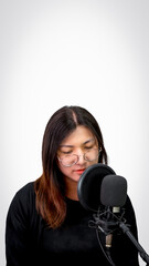 Beautiful asian woman (LGBTQ) is a singer. She enjoying sing a song or karaoke in music studio with microphone condenser and headphones for fun or voice creative