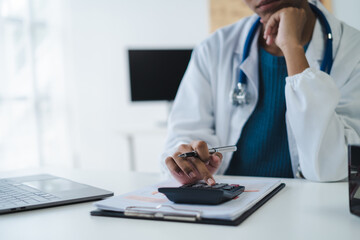 Doctor working in hospital use calculator, Healthcare and medical concept.