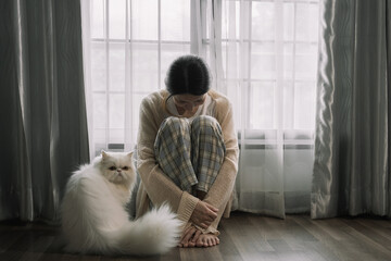 Sad and depressed young female sitting on the floor in the room, sad mood,feel tired, lonely and...