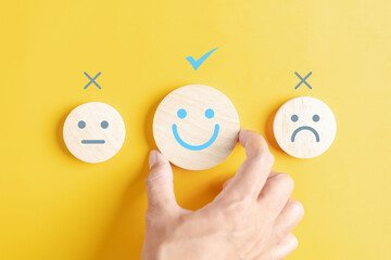 Hands holding blue happy smile face among sad face mental health positive thinking and growth mindset, mental health care recovery to happiness emotion. - obrazy, fototapety, plakaty