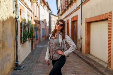 Fototapeta premium Tourist woman on old Toulouse town street, France, South Europe