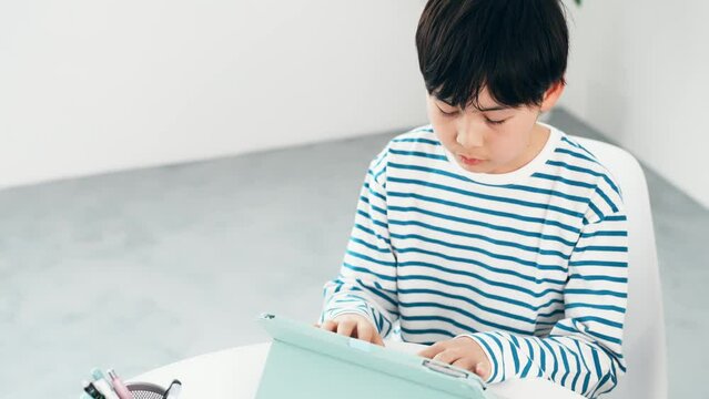 タブレットの画面をタッチする男の子