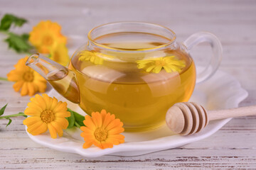 Medicinal calendula flower tea in a glass teapot.Close-up.

